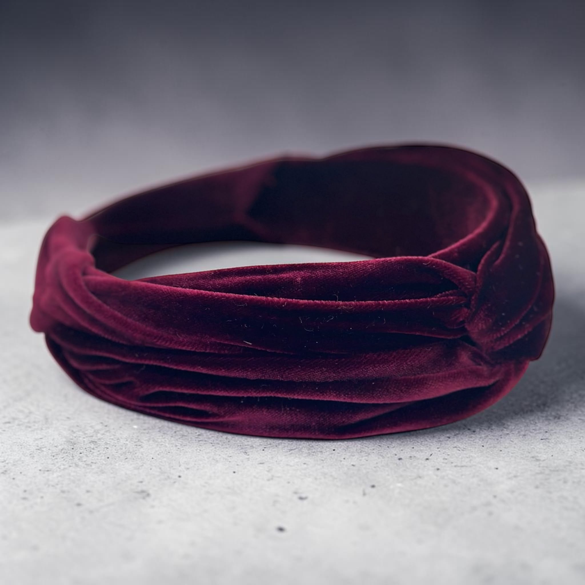 Silk velvet detail on a deep burgundy draped headband, Maria Monica London