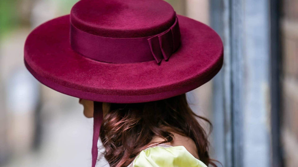 Deep berry wide brim occasion hat worn at the races, handmade in London by Maria Monica London