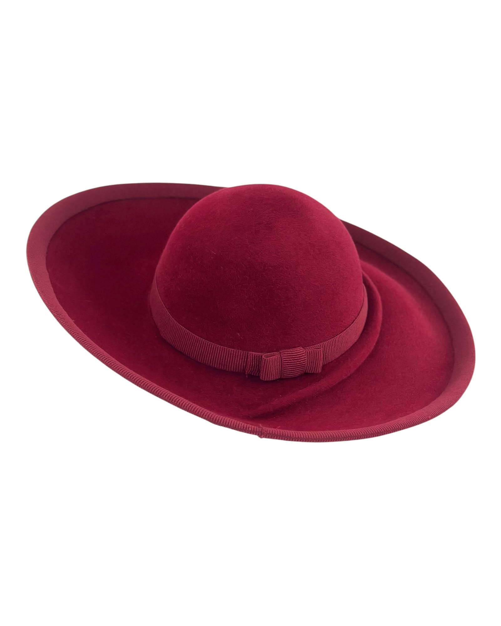 Deep burgundy asymmetric felt hat with a wide upturned brim and bound edge, handmade by couture milliner Maria Monica London