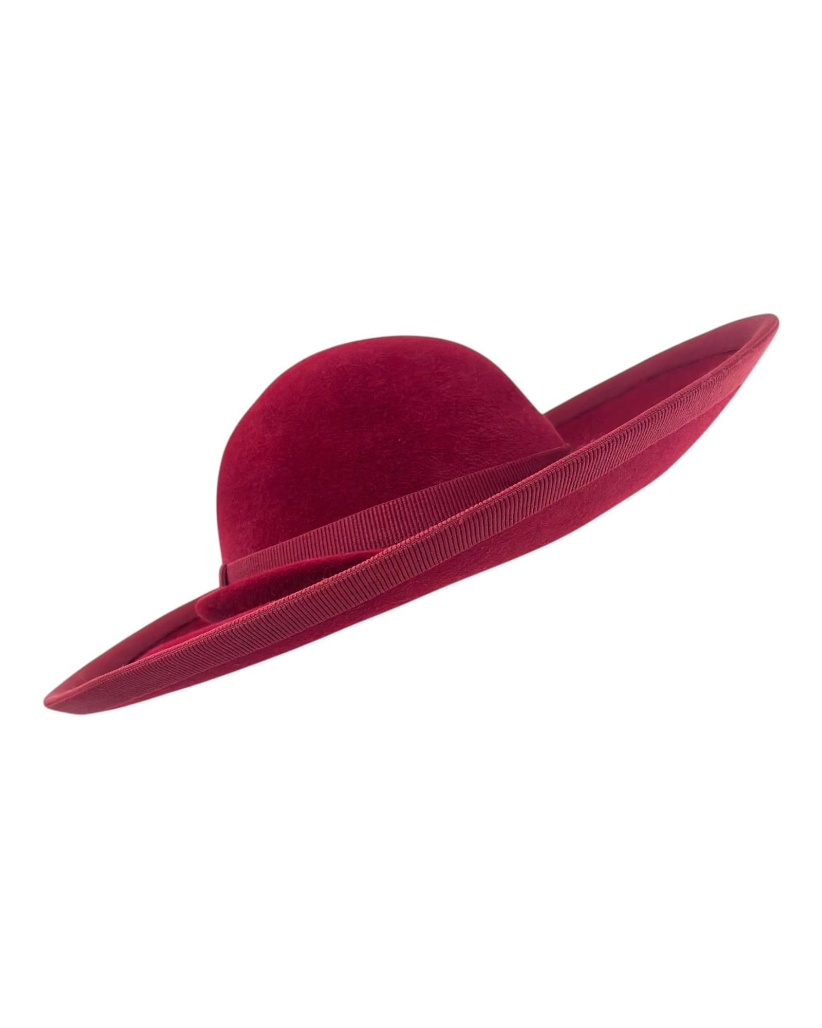 Side profile of the deep burgundy premium felt hat showing its asymmetric silhouette and sweeping brim, couture millinery handmade in London