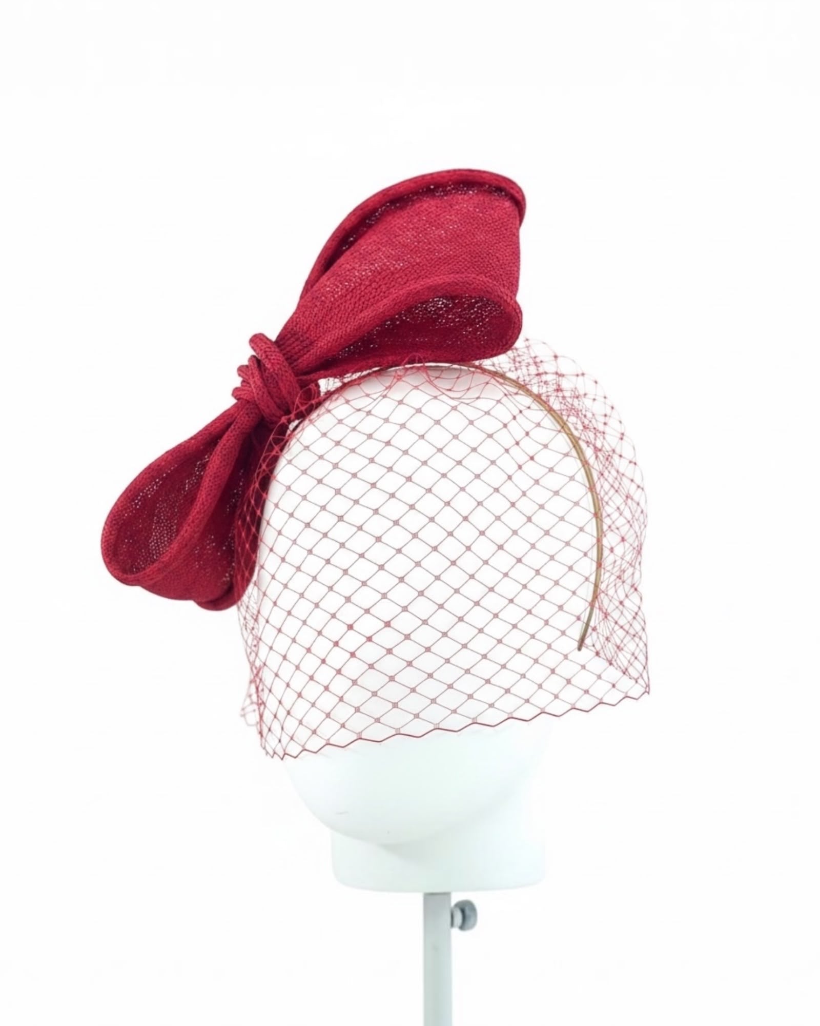 Crimson parasisal straw bow seen from the side, showing the looped bow and the crimson veil falling over the face, Maria Monica London