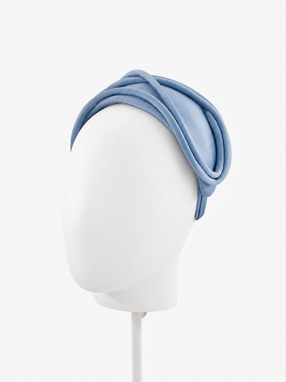 Ice blue satin headband with a raised piped edge curving over the crown, on a display head