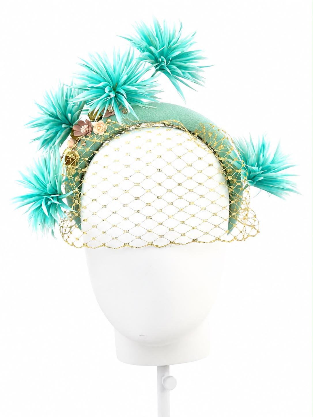 Aqua mint feather flower headband with fine gold veiling and small blush ceramic blooms, shown from the front on a display head, Maria Monica London