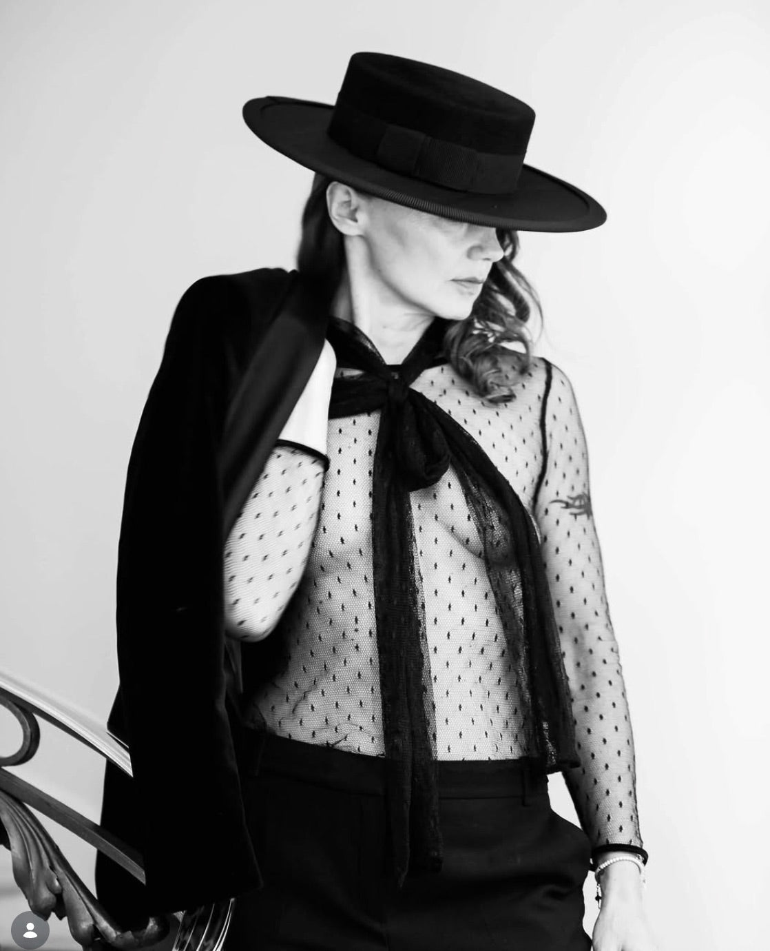 Monika Perlinska in a black wide brim boater and sheer dotted blouse, black and white portrait