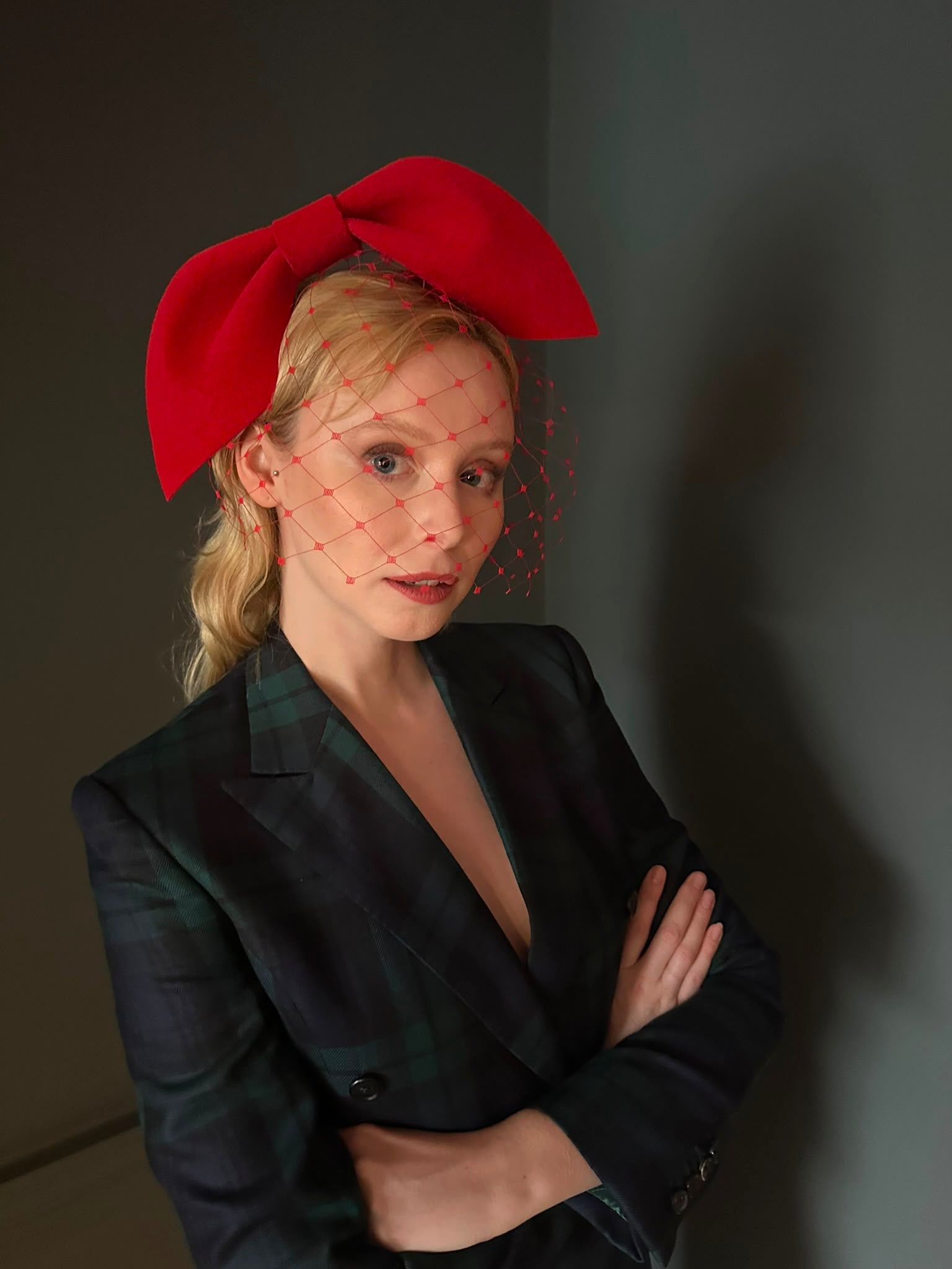 Model wearing the scarlet red sculpted felt bow with red veil, Maria Monica London
