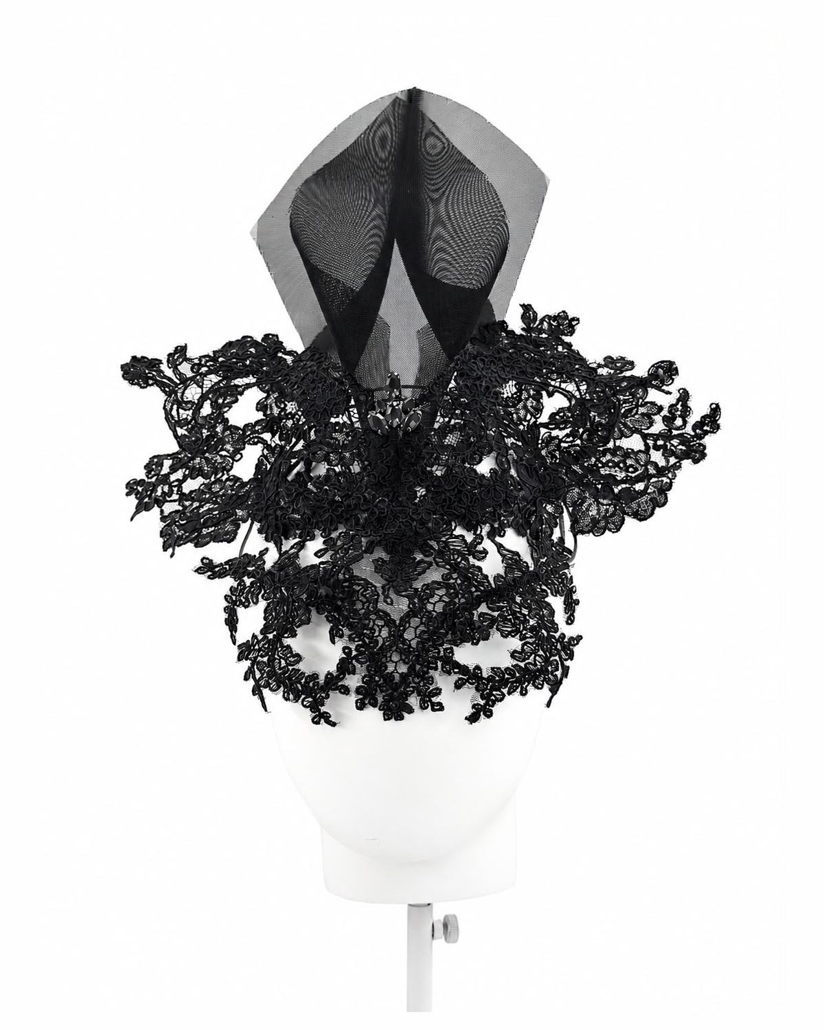 Black lace mask headpiece with a sheer black crin spire on a display head, Maria Monica London